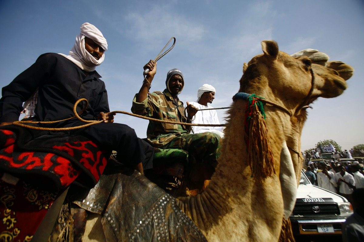 FILE PHOTO: Sudanese men ride camels as they gather to attend a speech by Sudanese President during his visit to El Daein in Eastern Darfur on April 5, 2016. AFP/Ashraf Shazly