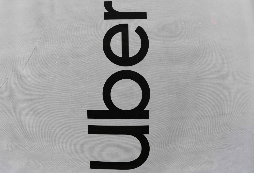 The Uber logo is on display at the Uber Elevate Summit June 12, 2019 in Washington, DC.  / AFP / EVA HAMBACH