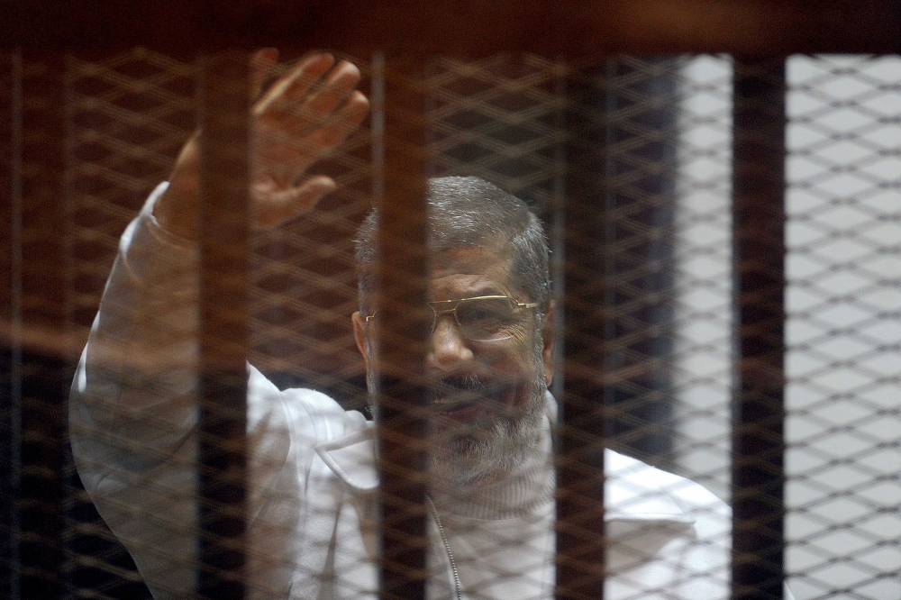 Ousted Egyptian President Mohamed Morsi standing inside a glass defendant's cage during first session in the trial where Morsi and 10 other co-defendants face on charges of spying for Qatar, in Cairo, Egypt.  Ahmed Omar - Anadolu