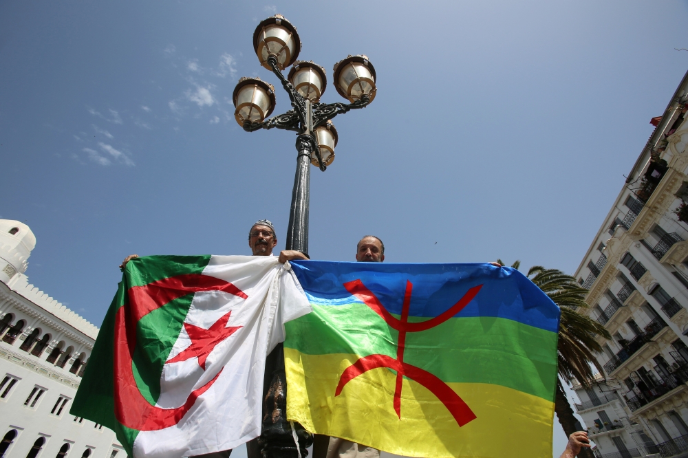Demonstrators carry Algerian and Amazigh flags during a protest demanding the removal of the ruling elite in Algiers, Algeria June 21, 2019. Reuters/Ramzi Boudina