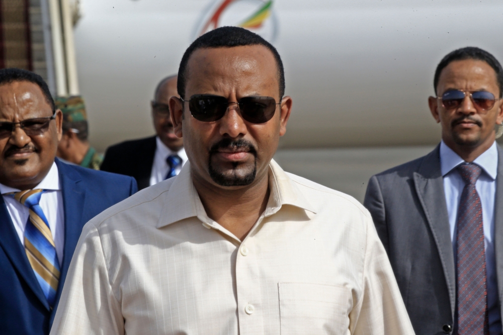(FILES) In this file photo taken on June 07, 2019 Ethiopia's Prime Minister Abiy Ahmed (C) arrives at Khartoum international airport on June 7, 2019. AFP / ASHRAF SHAZLY