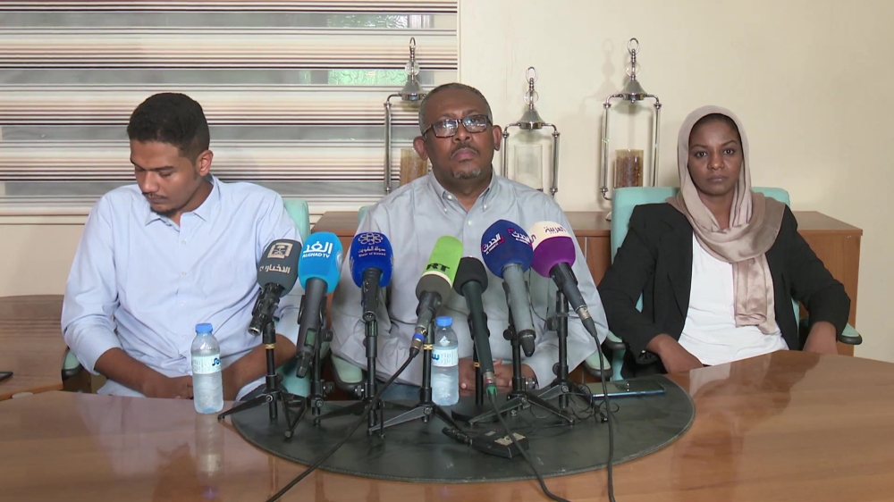 This AFPTV screen grab from a video made on June 23, 2019 shows Babiker Faisal (C), one of Sudan's protest leaders reading out a statement saying that they have accepted the creation of a civilian-majority governing body for a political transition in Suda