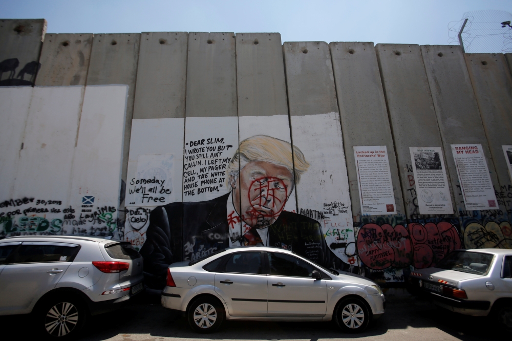 A mural depicting US President Donald Trump is seen on a section of the Israeli barrier in Bethlehem, in the Israeli-occupied West Bank June 23, 2019. Reuters/Mussa Qawasma 