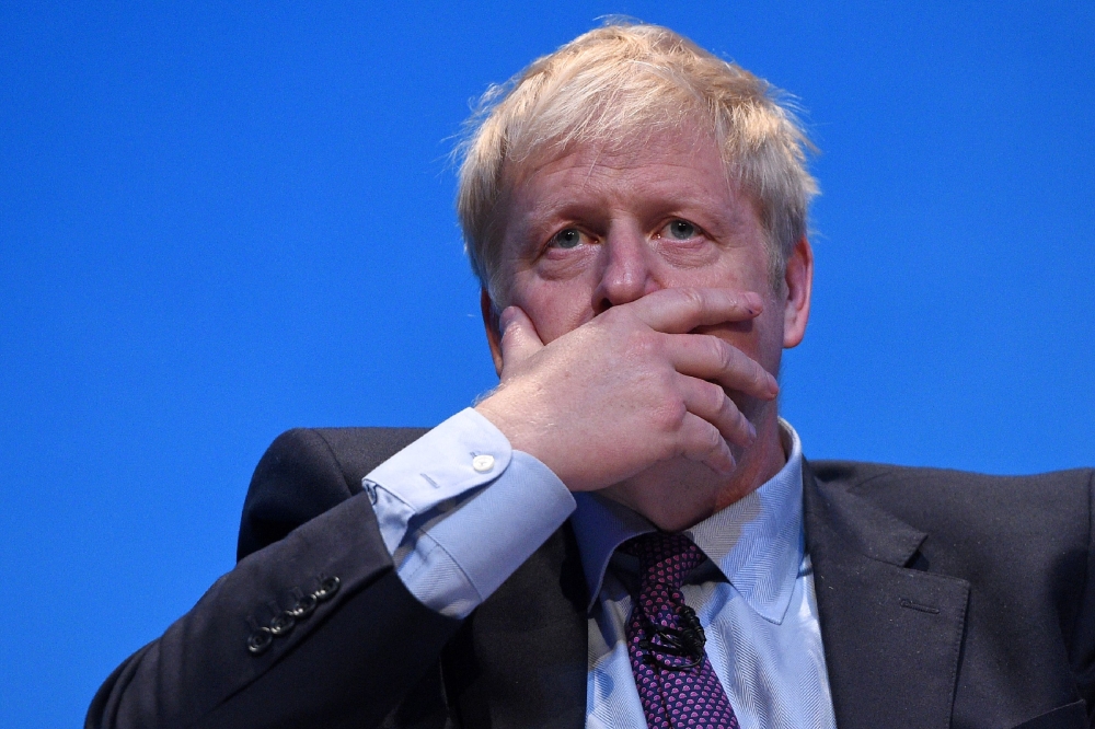 File photo of Conservative MP Boris Johnson gestures as he answers questions from journalist Iain Dale as he takes part in a Conservative Party leadership hustings event in Birmingham, central England on June 22, 2019. / AFP / Oli SCARFF 