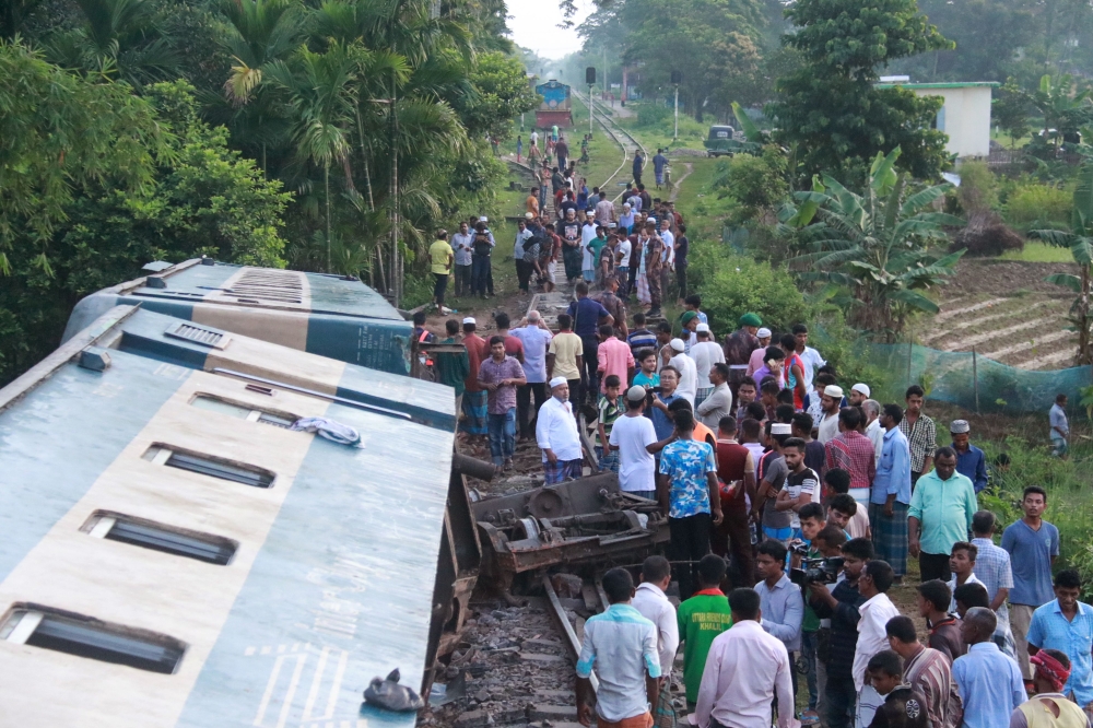 Bangladeshi onlookers gather around a derailed train after a bridge collapse in Kulaura on June 24, 2019. AFP / STR