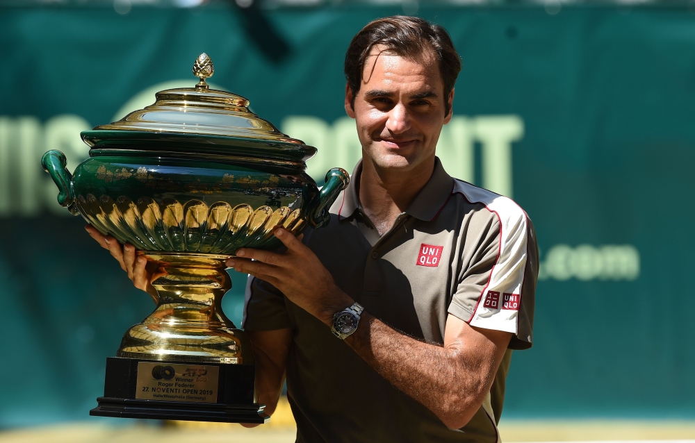 Roger Federer from Switzerland poses with the trophy after he won his final match against David Goffin from Belgium at the ATP tennis tournament in Halle, western Germany, on June 23, 2019. / AFP / CARMEN JASPERSEN
