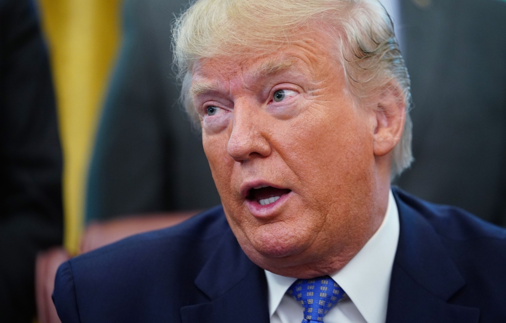 FILE PHOTO: US President Donald Trump speaks before signing an executive order in the Oval Office of the White House in Washington, DC.  AFP / MANDEL NGAN