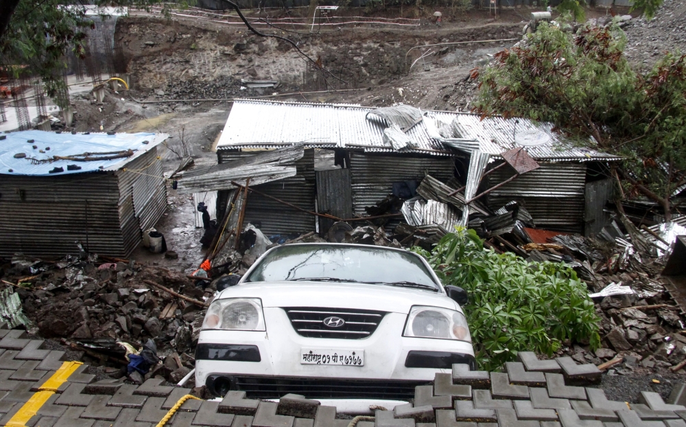 A damaged vehicle is seen at the site of a wall collapse in Pune on June 29, 2019.  AFP / STR