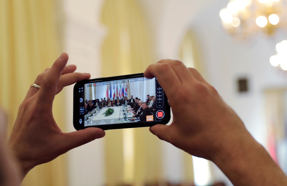 A journalist takes a picture as Iran's top nuclear negotiator Abbas Araqchi and Secretary General of the European External Action Service (EEAS) Helga Schmit attend a meeting of the JCPOA Joint Commission in Vienna, Austria, June 28, 2019. Reuters/Leonhar