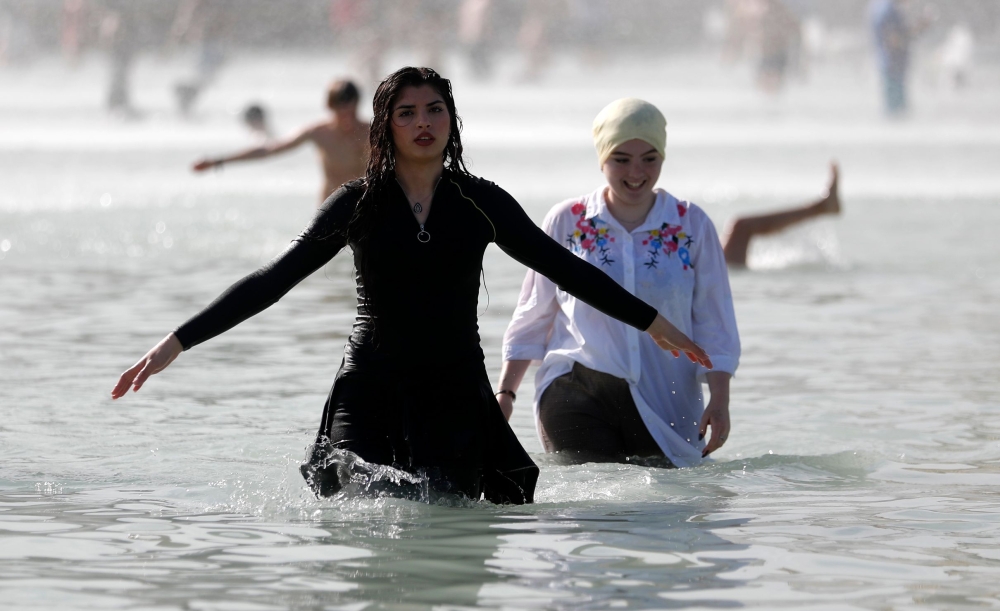 Two girls cool themselves down in the Trocadero Fountain near the Eiffel Tower in Paris during a heatwave on June 28, 2019. The temperature in France on June 28 surpassed 45 degrees Celsius (113 degrees Fahrenheit) for the first time as Europe wilted in a