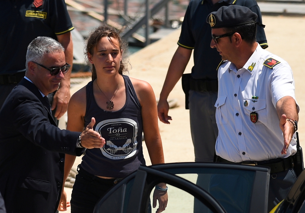 FILE PHOTO: Carola Rackete, the 31-year-old Sea-Watch 3 captain, disembarks from a Finance police boat and is escorted to a car, in Porto Empedocle, Italy July 1, 2019. REUTERS/Guglielmo Mangiapane/File Photo