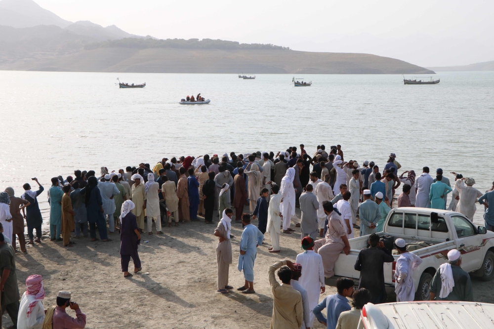 In this picture taken on July 3, 2019, Pakistani onlookers gather at the edge of the Indus River after a boat capsized in Haripur district. AFP / ATIF HUSSAIN