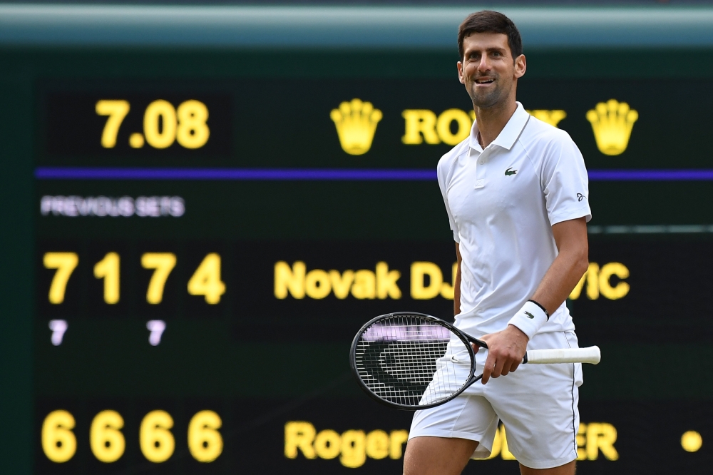 Serbia's Novak Djokovic celebrates beating Switzerland's Roger Federer during their men's singles final on day thirteen of the 2019 Wimbledon Championships at The All England Lawn Tennis Club in Wimbledon, southwest London, on July 14, 2019. AFP / Ben Sta