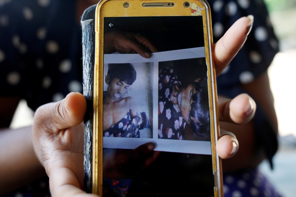 Thein Mya Yi shows a photo of Their Tun Sein, husband of Ah Hla, who died in custody, provided to the families by the prison staff, in Mrauk U, Rakhine state, Myanmar, June 29, 2019. Reuters/Ann Wang
 