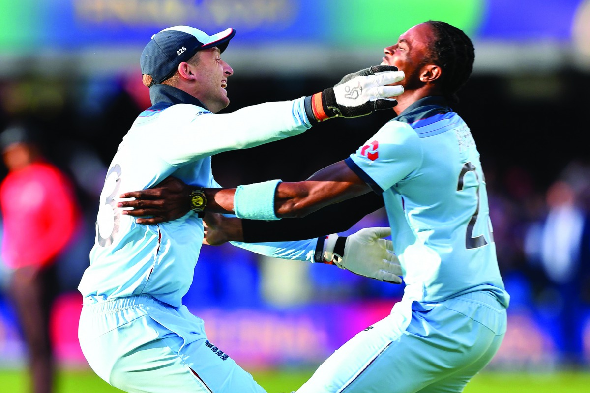 England's Jos Buttler (L) and England's Jofra Archer celebrates after they win the super over to win the 2019 Cricket World Cup final between England and New Zealand at Lord's Cricket Ground in London on July 14, 2019.  AFP / Paul Ellis 
