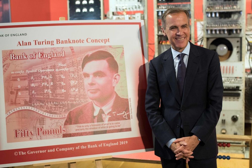 Mark Carney, governor of the Bank of England, poses for a photograph beside the concept design for the new Bank of England fifty pound banknote, featuring mathematician and scientist Alan Turing, during the presentation at the Science and Industry Museum 