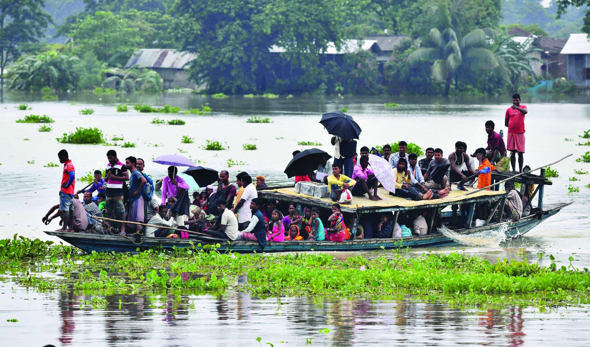 Villagers travel on a boat in the flood affected Jhargaon village in Morigaon district of India's Assam state on July 15, 2019.  AFP / Biju Boro