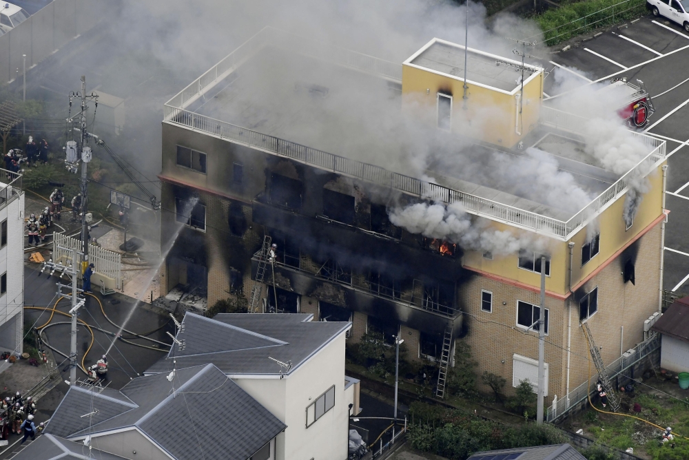 Firefighters battling fires at the site where a man started a fire after spraying a liquid at a three-story studio of Kyoto Animation Co. in Kyoto, western Japan, in this photo taken by Kyodo, July 18, 2019. Credit: Kyodo/via Reuters