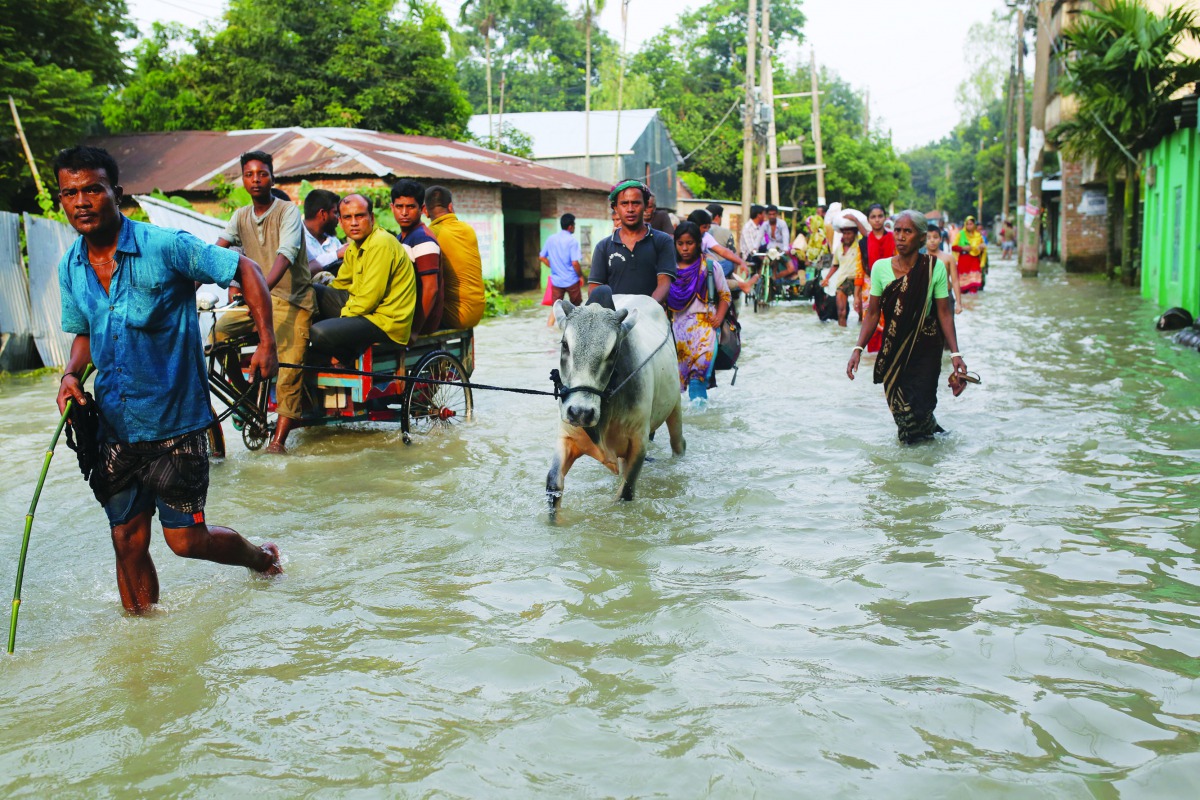 People move along a flooded road in Gaibandha, Bangladesh July 18, 2019. Reuters