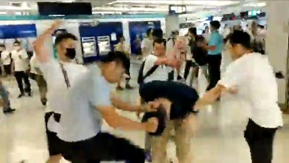 Men in white t-shirts and face masks attack anti-extradition bill demonstrators and reporters at a train station in Hong Kong, China, July 21, 2019, in this still image obtained from a social media live video. (Courtesy of Stand News/Social Media via REUT