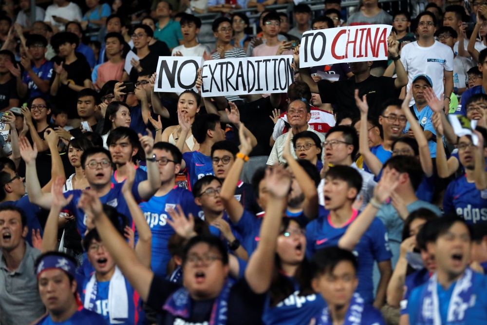Fans hold an anti-extradition bill banner during a friendly match between Manchester City Football Club and Kitchee, in Hong Kong, China July 24, 2019. (REUTERS/Tyrone Siu)