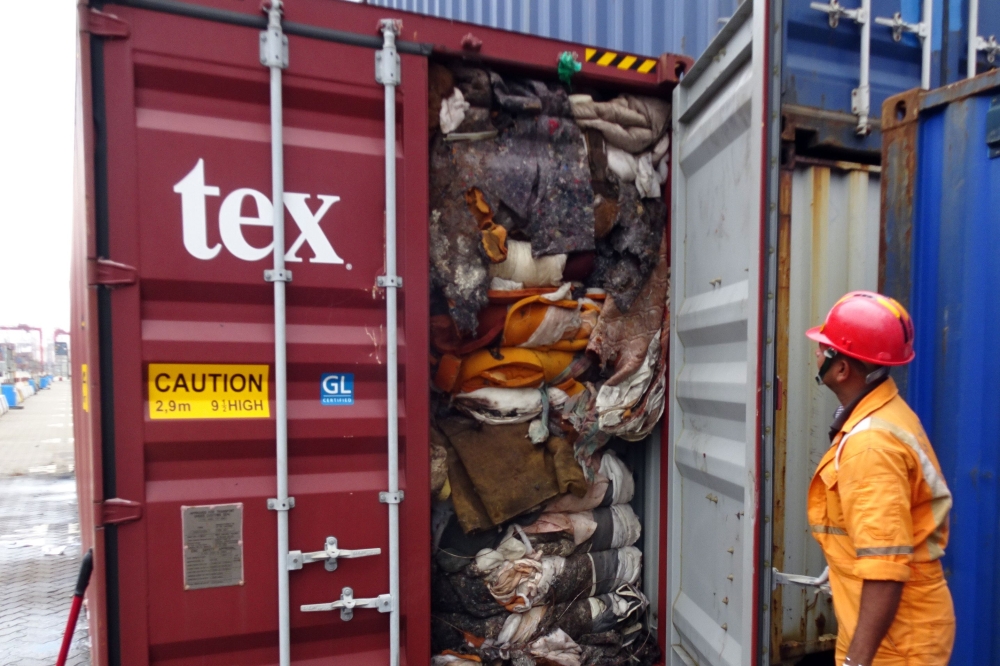In this handout picture provided by Sri Lankan Customs on July 23, 2019, a customs official inspects the load of a container at a port in Colombo. Sri Lanka customs on July 23 ordered the return of container loads of hazardous mortuary and clinical waste 