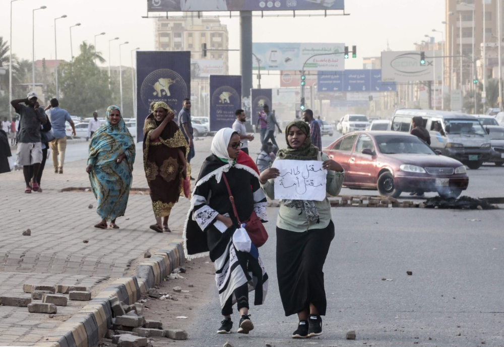 Sudanese protesters carry a placard during a rally in the capital Khartoum to condemn the 