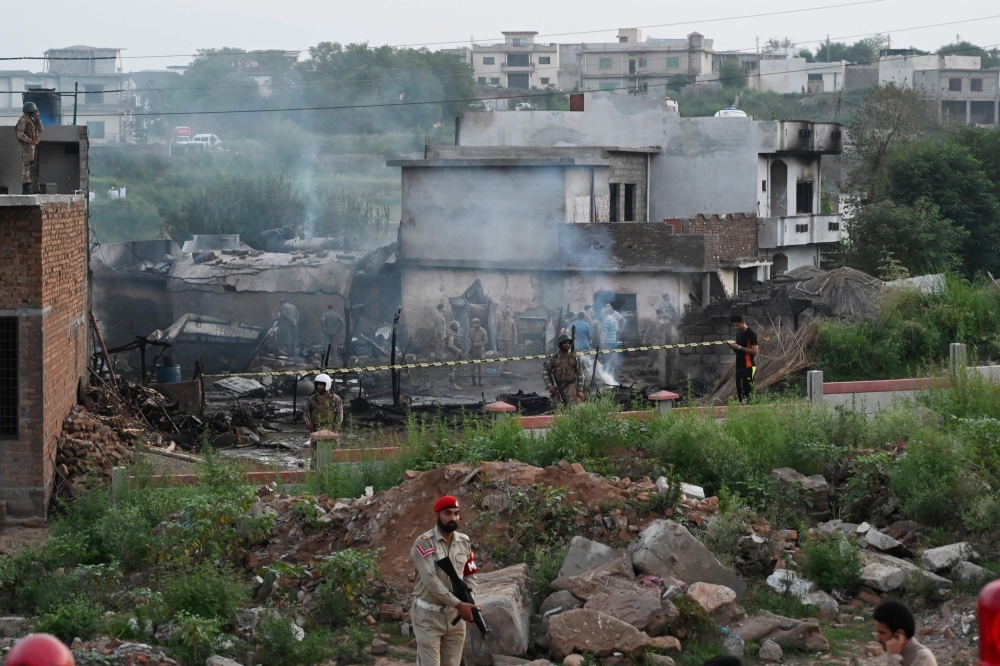 Military personnel work at the scene where a Pakistani Army Aviation Corps aircraft crashed in Rawalpindi on July 30, 2019. (AFP / AAMIR QURESHI)