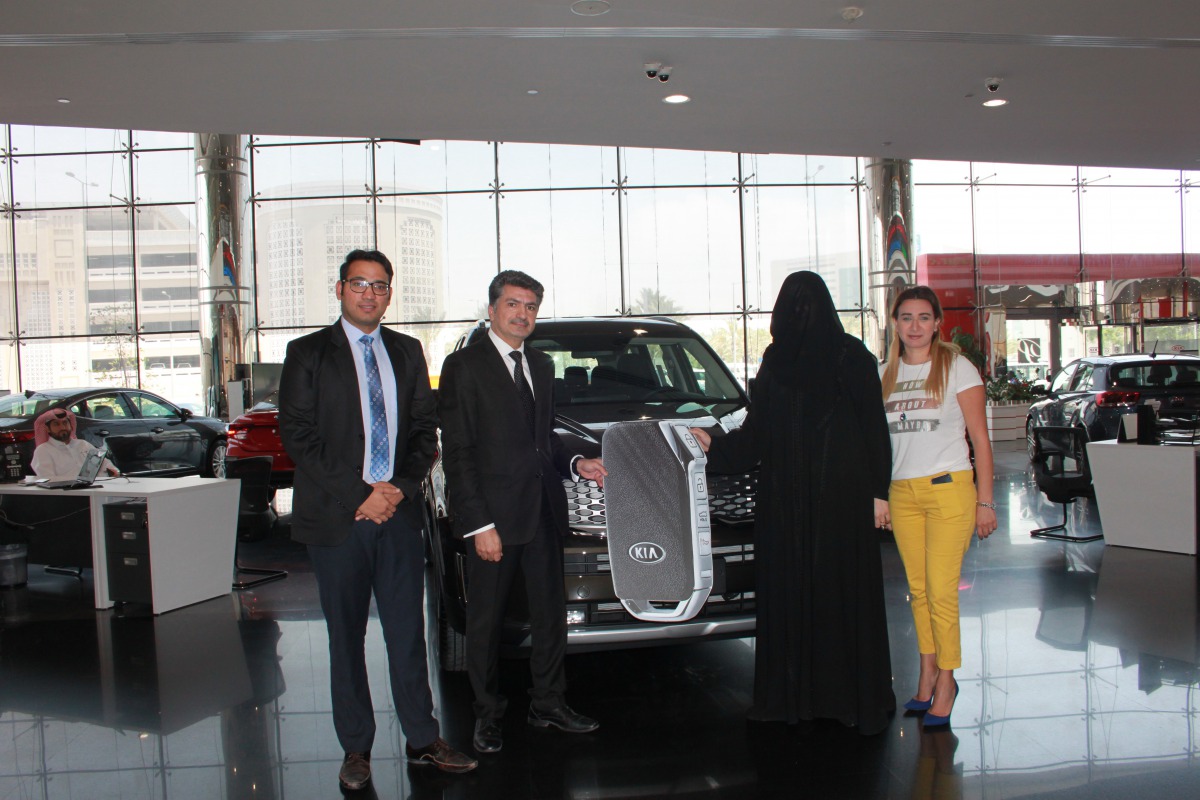 Al-Attiya Motors and QSports representatives Aya Kassab, Head of Business Development Unit and Qazi Yousri, Media Manager, hand over the keys of the Kia Telluride to the winner of the SEC Raffle Draw, Samah Mohammed S M, in a ceremony held at the Al Sadd 