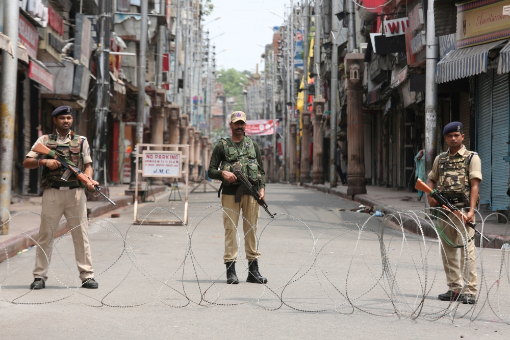 Indian security personnel stand guard along a deserted street during restrictions in Jammu, August 5, 2019. (REUTERS/Mukesh Gupta)