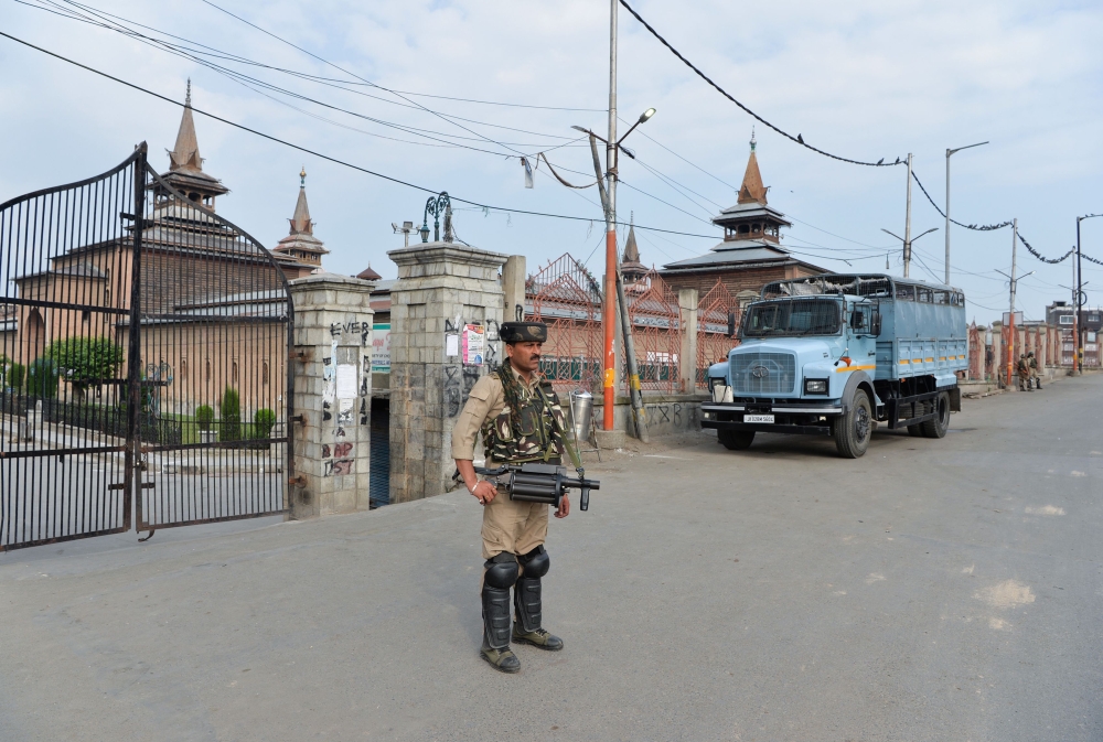 A security personnel stands guard on a street during a curfew in Srinagar on August 6, 2019.  AFP / Sajjad HUSSAIN
