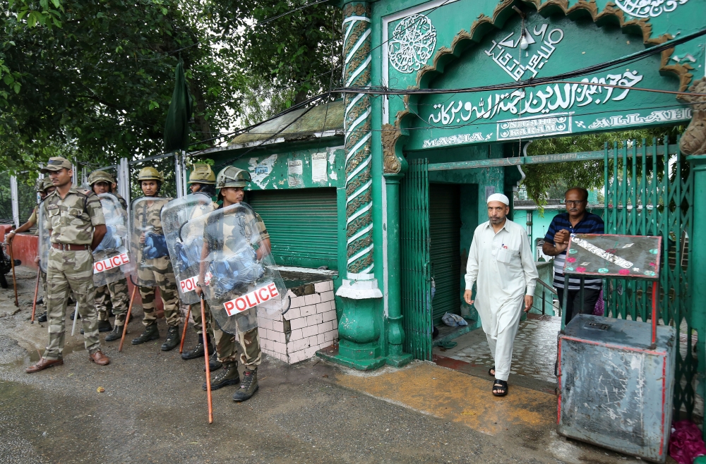 A man leaves a mosque after offering Friday prayers as Indian security force personnel stand guard during restrictions following the scrapping of the special constitutional status for Kashmir by the Indian government, in Jammu August 9, 2019. (REUTERS/Muk