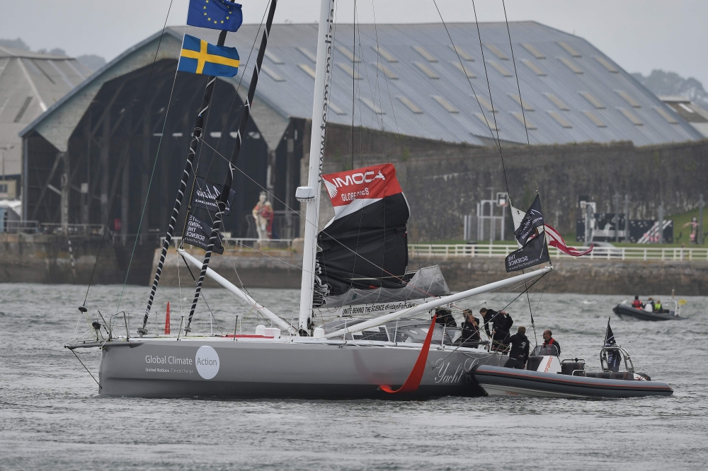 Swedish climate activist Greta Thunberg (C) climbs aboard the Malizia II IMOCA class sailing yacht from an RIB off the coast of Plymouth, southwest England, on August 14, 2019, as she prepares to start her journey across the Atlantic to New York where she