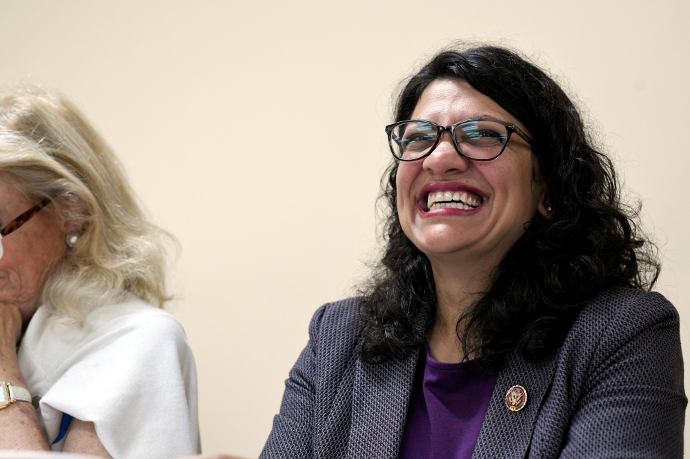 FILE PHOTO: U.S. Rep. Rashida Tlaib (D-MI) listens as Jim Pedersen of the A. Philip Randolph Institute speaks to the crowd during a town hall meeting featuring leadership from various voting rights organizations in Dearborn Heights, Michigan, U.S. July 20