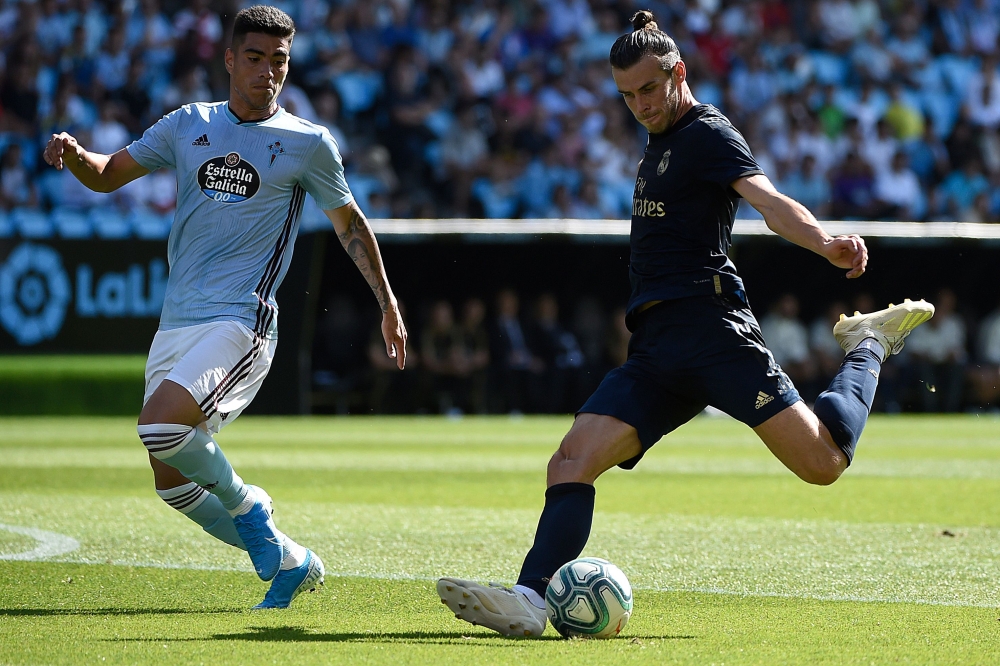 Real Madrid's Welsh forward Gareth Bale (R) challenges Celta Vigo's Uruguayan defender Lucas Olaza during the Spanish League football match between Celta Vigo and Real Madrid at the Balaidos Stadium in Vigo on August 17, 2019. / AFP / MIGUEL RIOPA