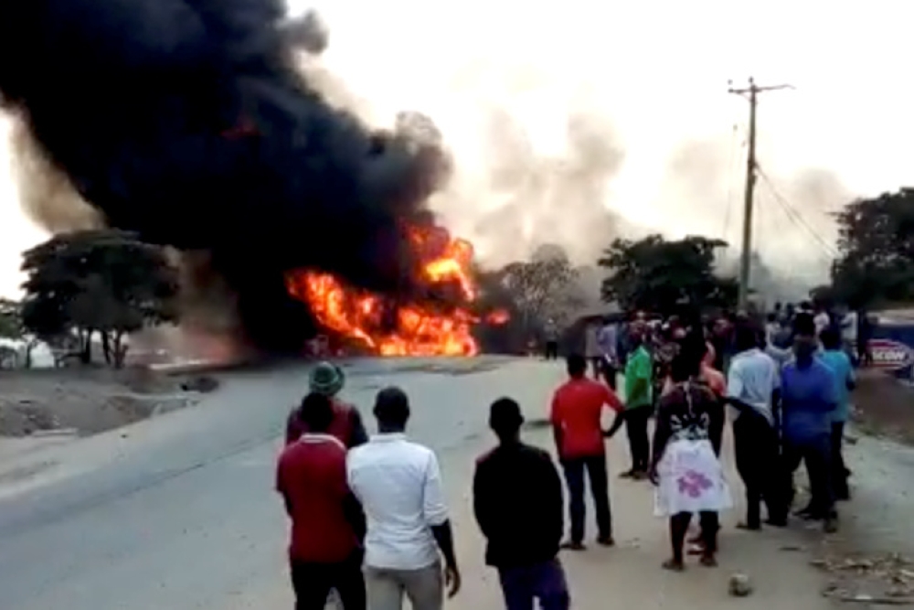 People look towards a fire following a fuel truck collision in Rubirizi, Uganda August 18, 2019 in this still image taken from social media video. 