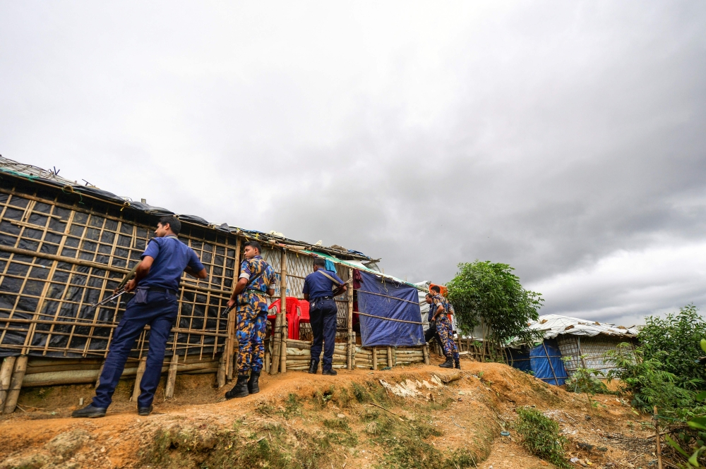 In this file photo taken on July 22, 2019, Bangladesh police personnel stand as they patrol inside Kutupalong refugee camp in Ukhia.  AFP / Munir UZ ZAMAN 