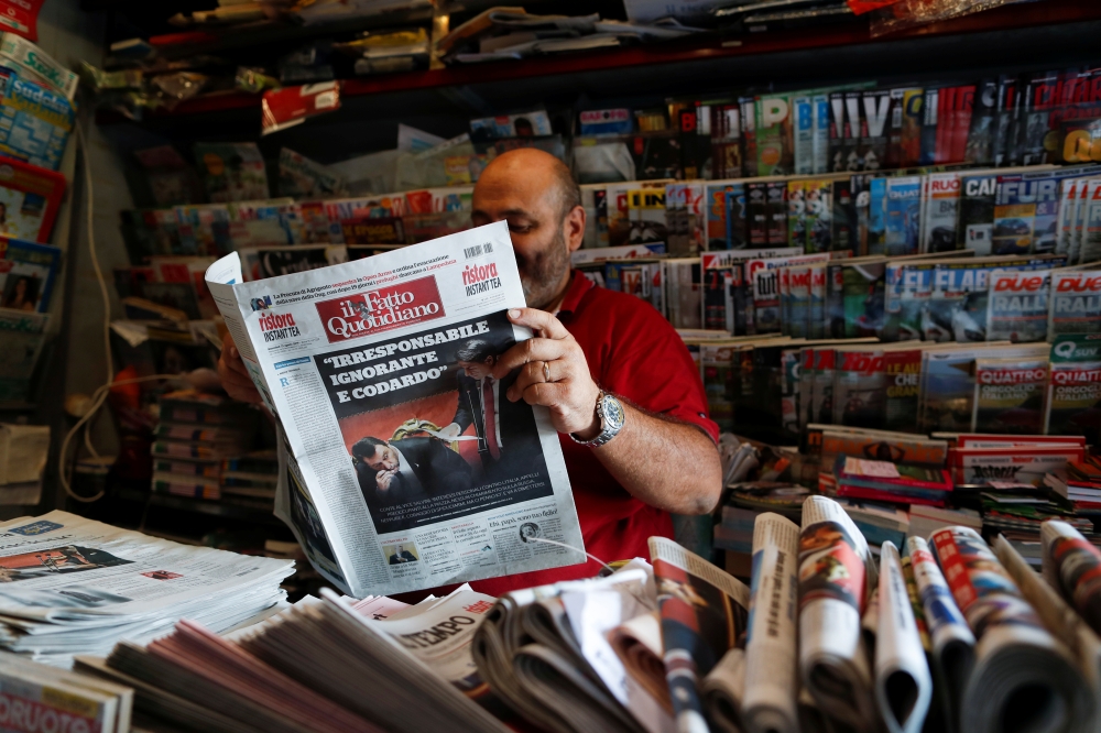 A kiosk owner reads a newspaper with news of Government crisis and the resignation of the prime minister Giuseppe Conte, in Rome, Italy, August 21, 2019. Reuters/Yara Nardi