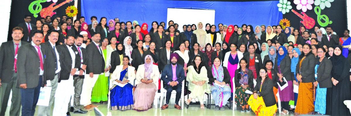 Teachers and other officials of the MES Indian School, posing for a group picture.