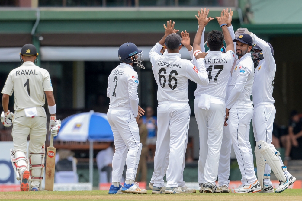Sri Lanka's Cricketers (R) celebrate after the dismissal of New Zealand's Cricketer Jeet Raval (L) during the third day of the final Cricket Test match between Sri Lanka and New Zealand at P. Sara Oval stadium in Colombo on August 24, 2019. AFP / LAKRUWAN