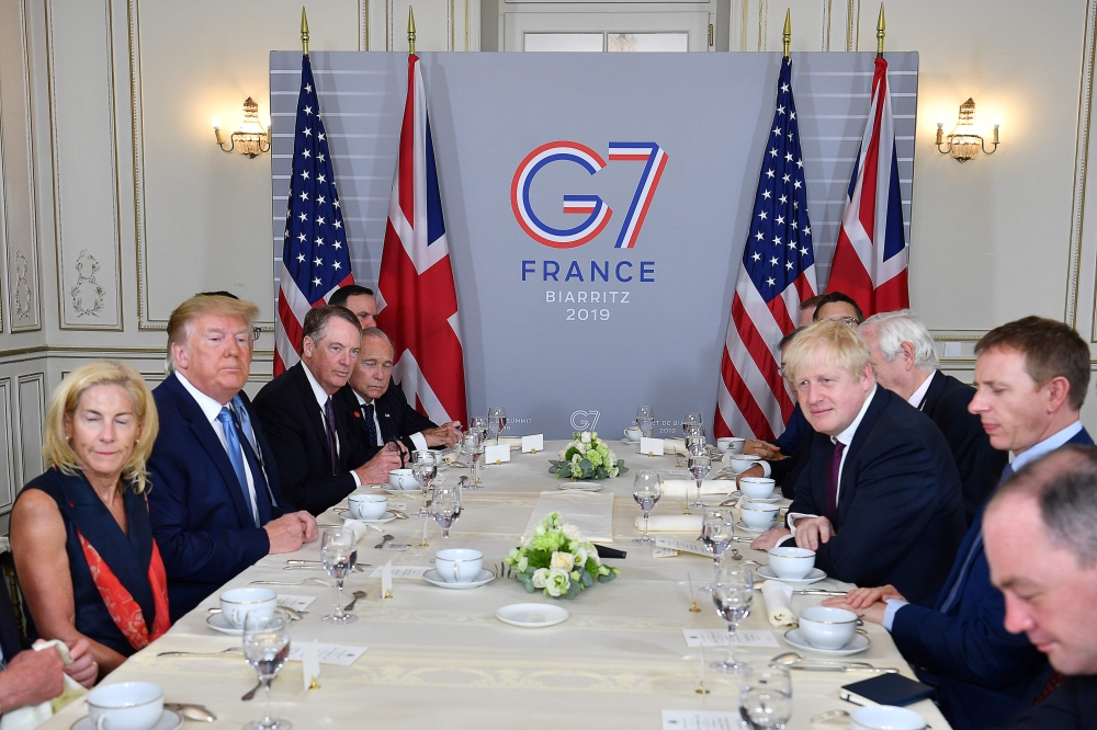 US President Donald Trump (2nd L) and Britain's Prime Minister Boris Johnson (3rd R) attend a working breakfast in Biarritz, south-west France on August 25, 2019, on the second day of the annual G7 Summit attended by the leaders of the world's seven riche