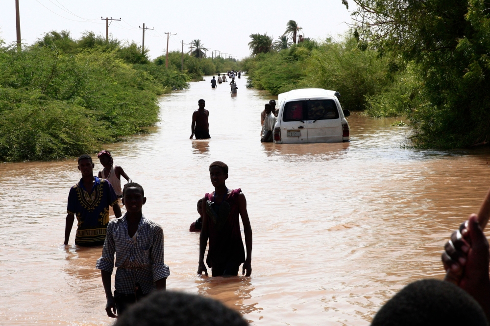 Sudanese people walk a flooded road in Wad Ramli village on the eastern banks of the Nile river on August 26, 2019. AFP / Ebrahim HAMID