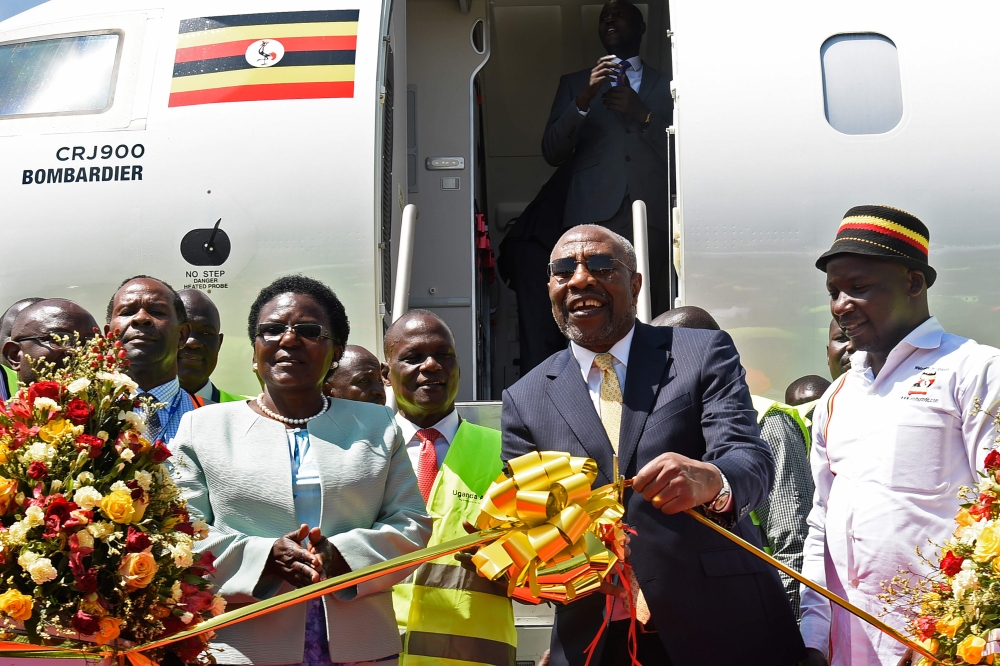 Uganda’s Prime Minister Ruhakana Rugunda (2R) flanked by Minister of World and Transprt Eng. Monica Azuba Ntege (2L) and the State Minister for Tourism Godfrey Kiwanda (R) take part in the launching ceremony of Uganda Airline’s maiden flight to Jomo Kenya