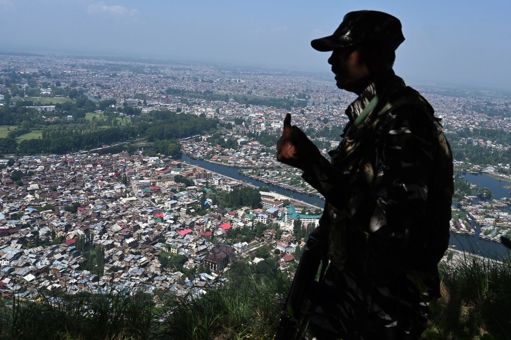 An Indian paramilitary trooper patrols at the top of a hill in Srinagar on August 25, 2019. / AFP / Tauseef Mustafa