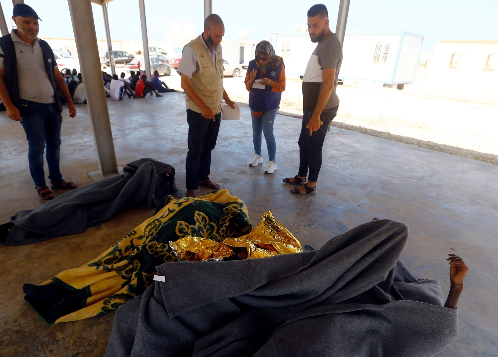 The bodies of rescued migrants are covered after being recovered and brought back to a Coast Guard Point at Al-Khums on August 27, 2019, after they were saved off the coast of Al-Khums, 100 kilometers east of the Libyan capital. AFP / Mahmud TURKIA
