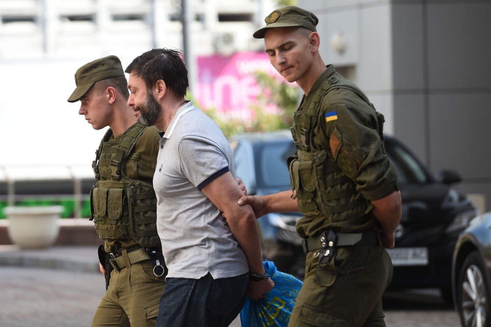 FILE PHOTO: Servicemen of the Ukrainian National Guard escort Ukrainian-Russian journalist Kyrylo Vyshynsky after his Kiev's Appeal Court hearing, in Kiev. AFP / Sergei SUPINSKY