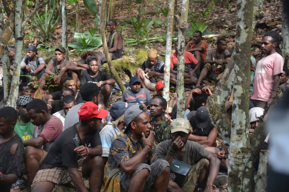 This handout picture taken and released on September 1, 2019, by the Indonesian military shows a group of Papuans, who took part in recent mass protests and currently seeking military's help to return to their homes, in Jayapura. / AFP / The Indonesian Mi