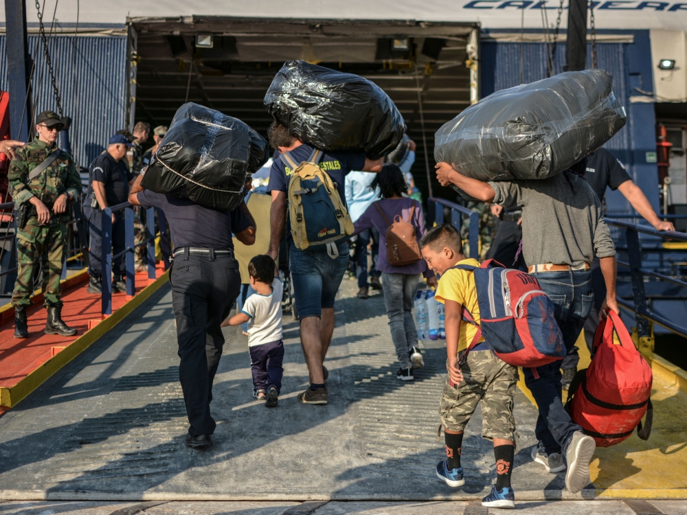 Refugees and migrants board a ship at the port of Mytilene, on the island of Lesbos on September 2, 2019, as hundreds of migrants leave Lesbos, helping to ease overcrowding at the Moria camp.  AFP / STRINGER