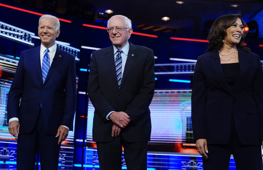 Joe Biden, Bernie Sanders and Kamala Harris pose before the start of the second US 2020 presidential election Democratic candidates debate in Miami, June 27, 2019. Reuters/Carlo Allegri