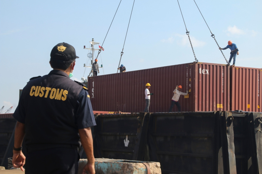 (FILES) This file photo dated July 29, 2019 shows Indonesian custom officers preparing to return containers filled with hazardous rubbish to their countries of origin, in Batam. AFP / SEI RATIFA